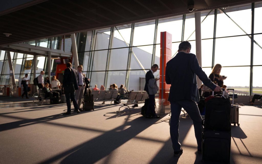 People waiting at airport gate in suits waiting for a flight