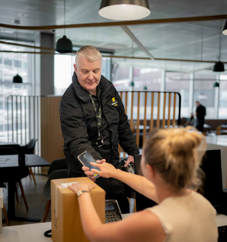 Addison Lee courier driver delivering a parcel to a woman in an office