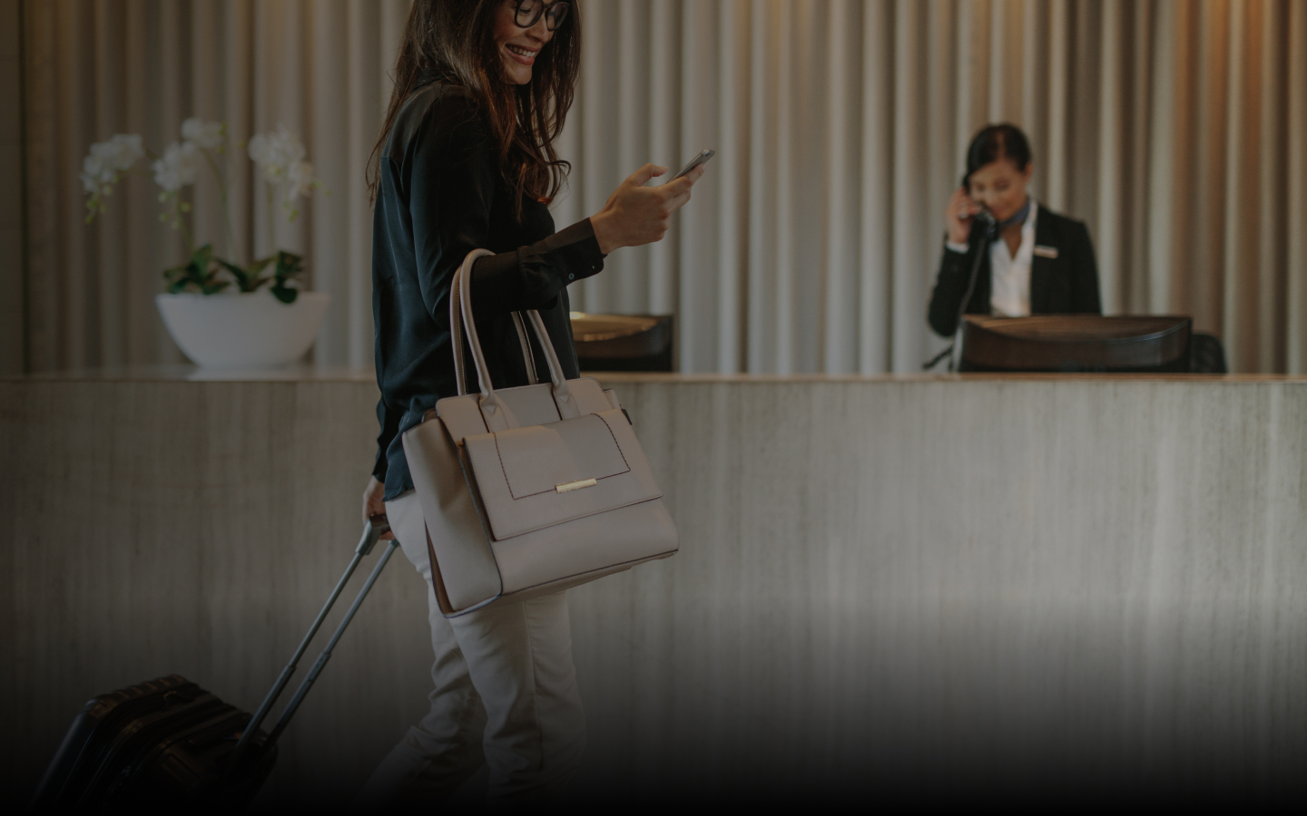 lady on her phone in hotel lobby using quickbooker
