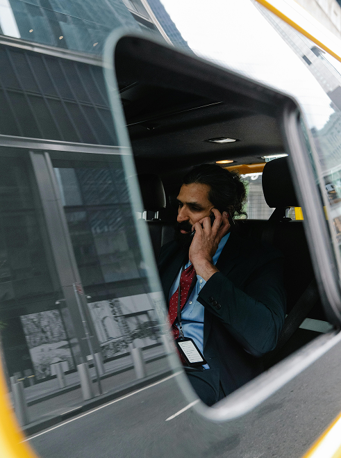 Man wearing a suit on the phone travelling to a business meeting