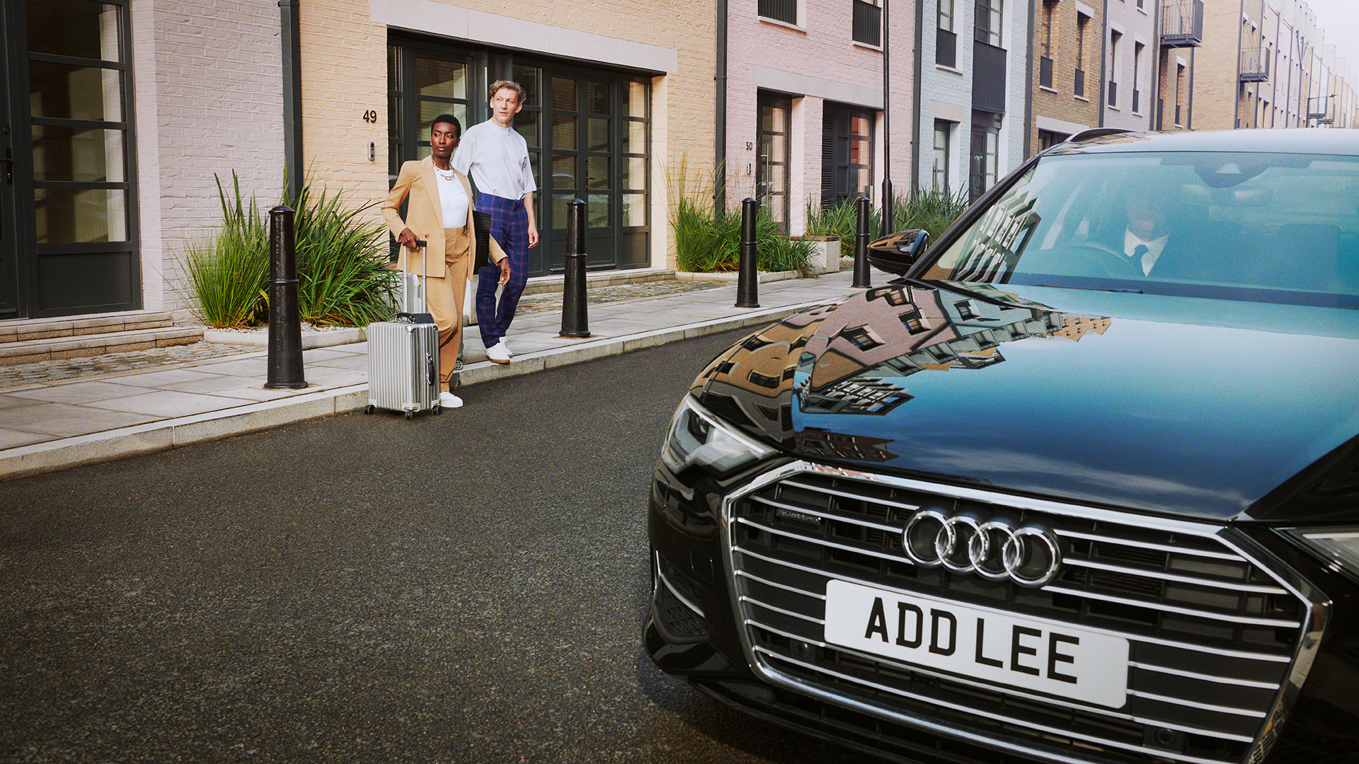 Addison Lee executive car and couple with suitcase