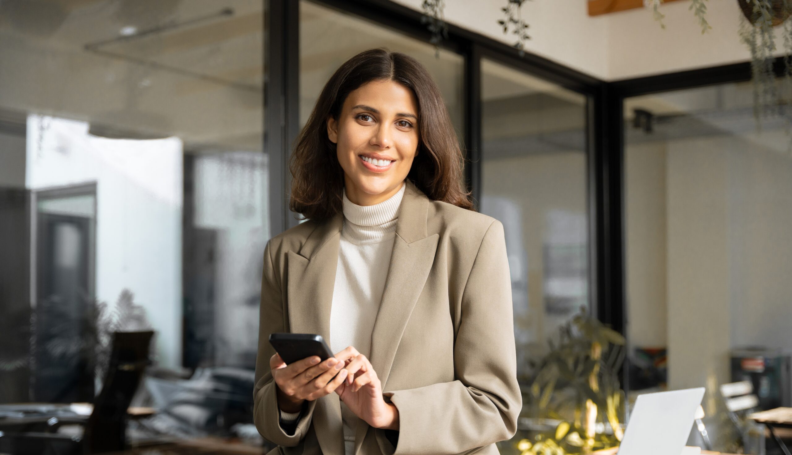 woman in the office on her phone booking an addison lee on her personal account