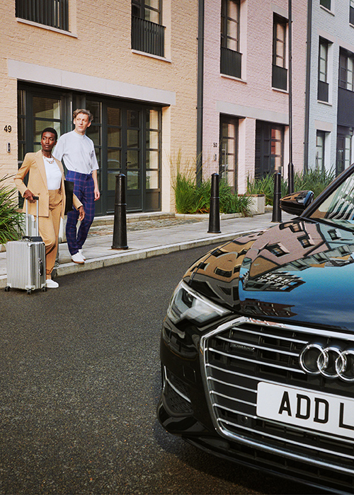 Addison Lee executive car with man and woman getting in with suitcase