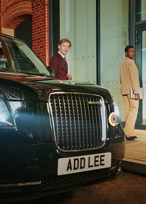 Addison Lee Black Taxi in London with man and woman walking into office