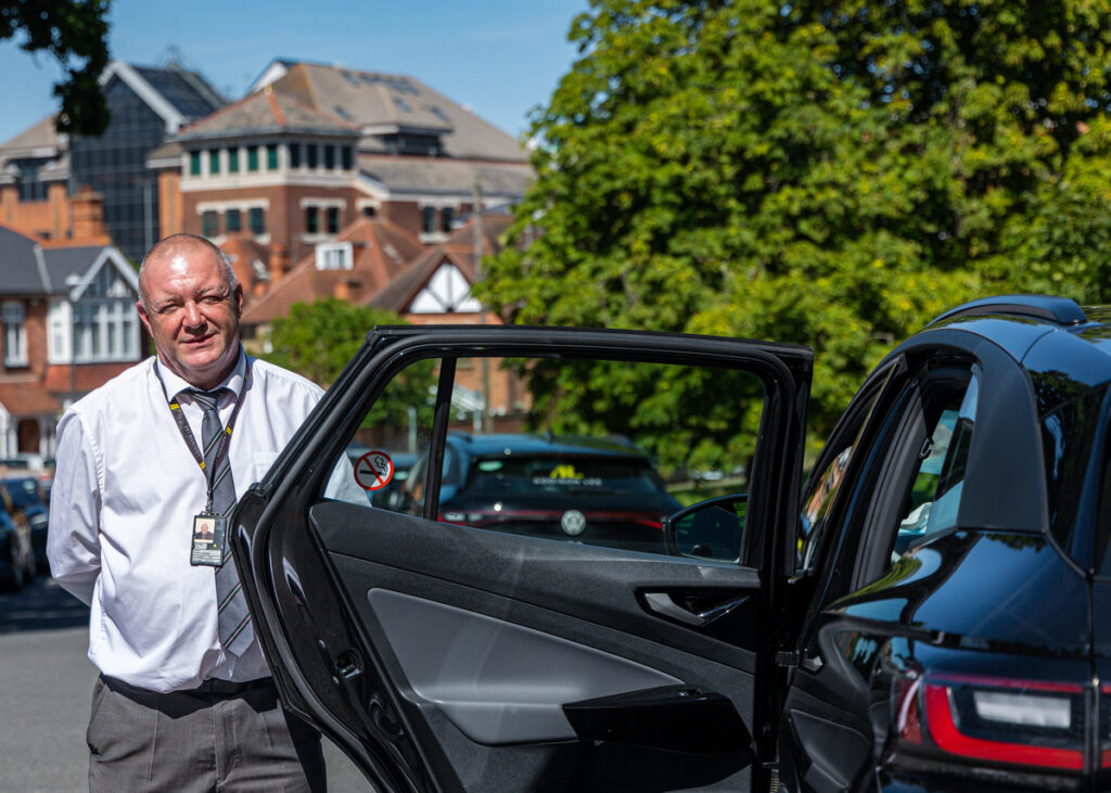 addison lee driver opening door on sunny day