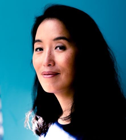 Woman with dark hair smiling at a camera